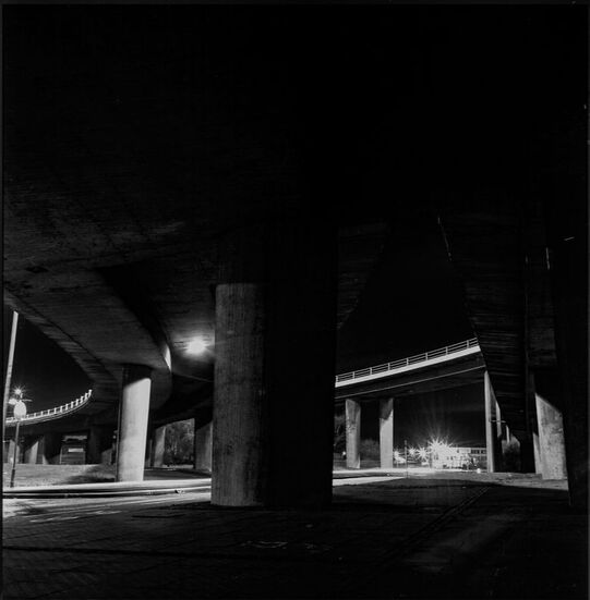 Night time view of the underside of Glasgow's concrete Kingstone Bridge which supports the M8 motorway as it stretches over the River Clyde.