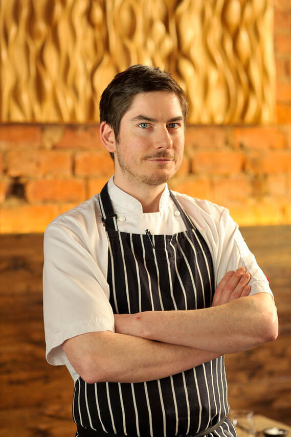 Chef Peter McKenna standing in chef uniform with arms folded for List editorial on his Glasgow restaurant, The Gannet